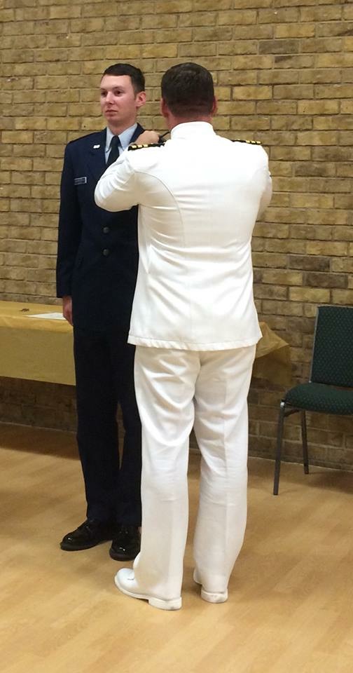 Commander Michael Horn, U.S. Navy, ret., placing shoulder boards on Civil Air Patrol Cadet Lieutenant Colonel Morgan Joslin