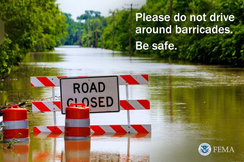 This graphic warns about driving around barricades during a flood, and encourages people to be safe. The text reads as follows: "Please do not drive around barricades. Be safe." Created by Loretta Kuo. Original photo by Steve Zumwalt/FEMA. Location: West Alton, Mo., June 6, 2013 -- Missouri Route 94 flooded.