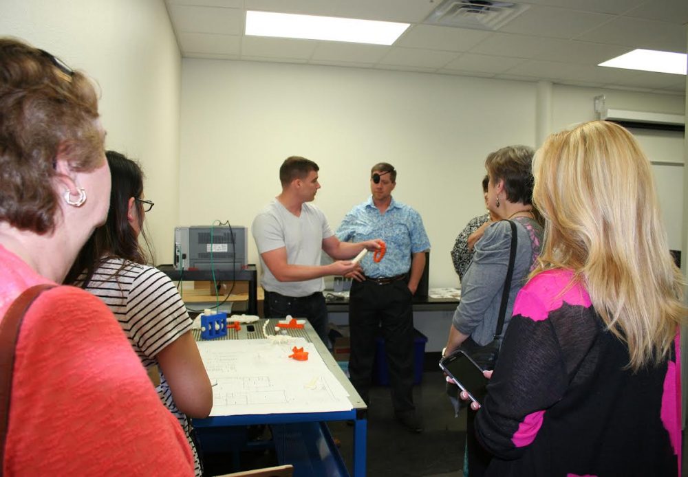 Instructor Chris Malone explaining the production of items in 3-D printing that will be offered at the new campus.