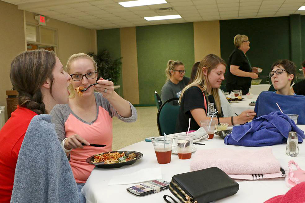 PRACTICING SKILLS Paris Junior College students in the licensed vocational nursing program recently practiced the art of feeding patients. They took turns in role-playing, simulating impairment in patients. Shown from left are Sulphur Springs students Michala Davis and Kasie Brantley, Karli Emmons of Cumby, and Mysti Dooley of Greenville.