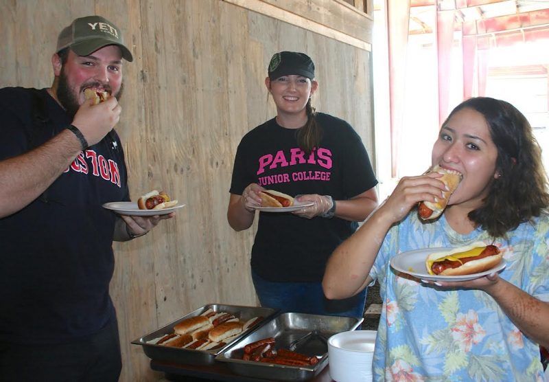 Paris Junior College-Sulphur Springs Center husband and wife students Brady and Daisy Pittman of Sulphur Springs, foreground, enjoy a quick hot dog lunch provided on campus during this first week of fall semester classes. Student Activities Coordinator Leanna Roberts, center, and Student Life Director Kenneth Webb provided the lunch.