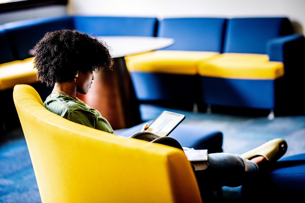 Texas A&M University Commerce student with tablet in Talbot Hall lounge