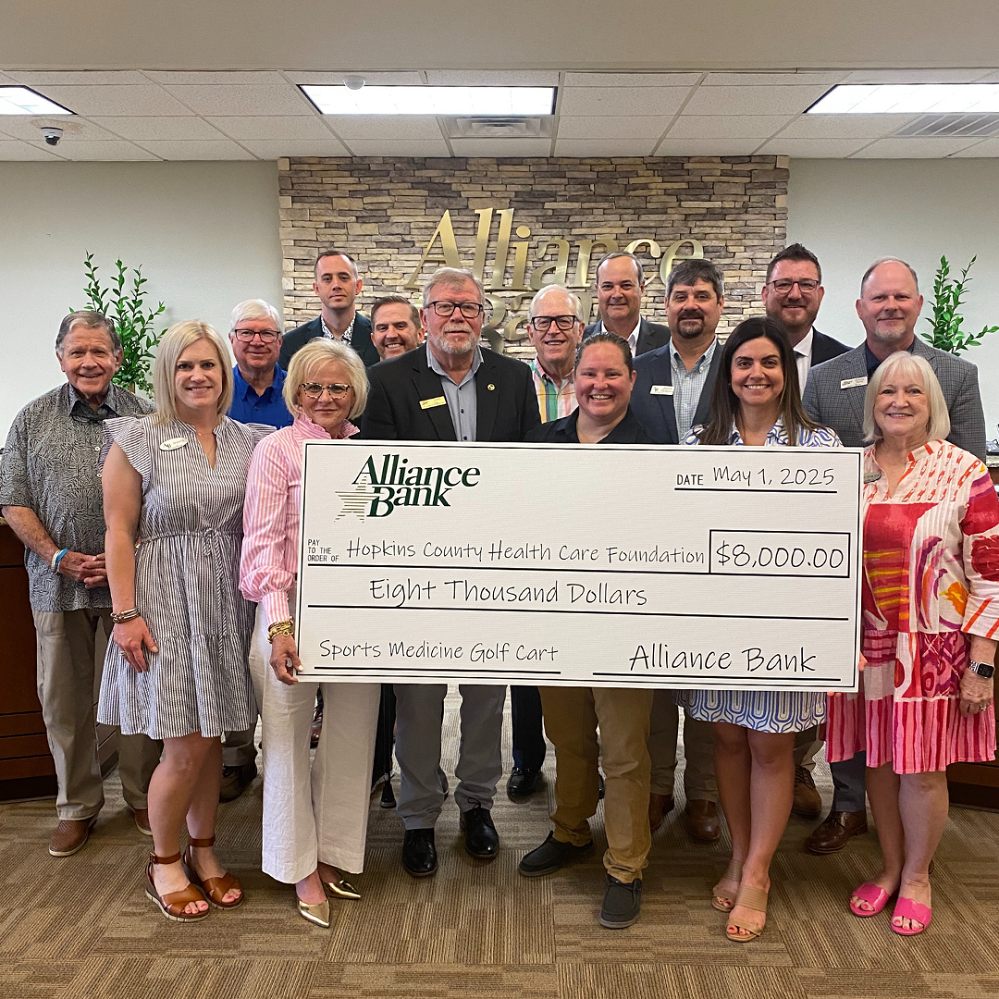 Representatives of Alliance Bank, CHRISTUS Mother Frances Hospital – Sulphur Springs, and the Hopkins County Health Care Foundation Board of Directors gathered at Alliance Bank for a photo to commemorate the donation of a medical golf cart to be used by the CMF-SS Sports Medicine Program. The golf cart will travel with the Mobile Athletic Training Room to area sporting and community events. Celebrating the donation are front row, left to right, Jessica Kultgen, Pam Black, James Law, Tracy Lott, Jennifer Heitman, and Ruth Ann Crowson. Back row, left to right, Mickey McKenzie, Brad Johnson, Brandon Harry, Kenny Rogers, Bob Weaver, Joseph Crouch, Jason Thompson, Randy Bench, and Kevin Monk.