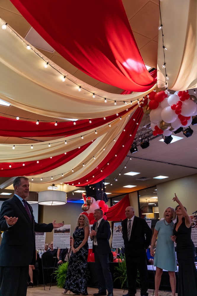 A perfectly timed photo. This photo captures the moment Johns Sellers and the Gala crowd realize the heads and tails tossed coin was caught in the dance floor decorations at the 2022 Gala, Under the Big Top. The show continued with a winner later declared. This is not the only time John’s coin got trapped in the decorations. To get your tickets or sponsor the 2026 Gala, visit Gala2026.GiveSmart.com or call the Foundation at 903-438-4799.