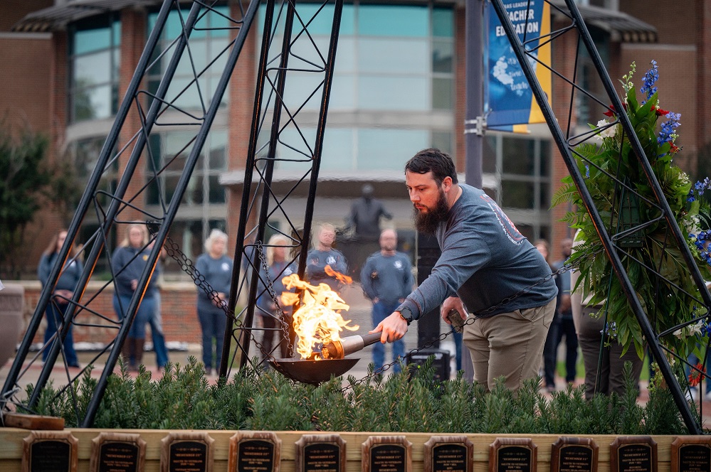 ETAMU alum, staff member and U.S. Navy veteran Casey Guliuzza lights the ceremonial flame at the 34th annual Veterans Vigil in 2024. | Photo by Tyler Holloway, East Texas A&M Marketing and Communications.