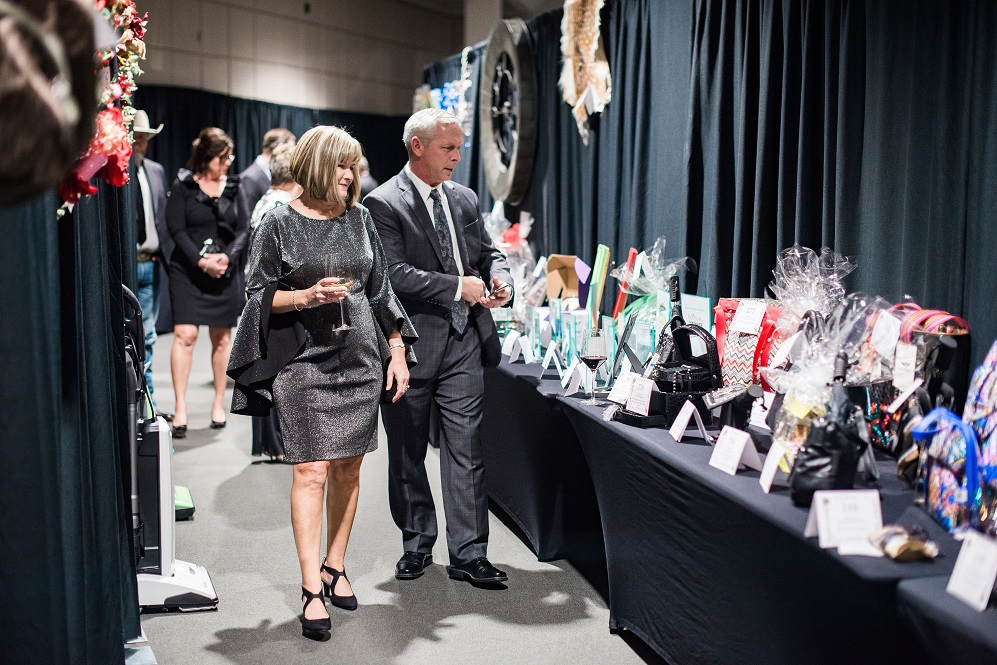 Viva La Gala! Win awesome auction items from the comfort of your own home in the Foundation’s online Auction Pre-Sale. Bidding opens February 2 at 8:00 a.m. and closes February 8 at 9:00 p.m. The Gala may have been postponed, but the winning doesn’t have to be! Visit Gala2026.GiveSmart.com to preview items and bid. Pictured here are Sarah and Don McCann of Clayton Homes browsing the Silent Auction items from the 2019 Vegas-themed Gala.