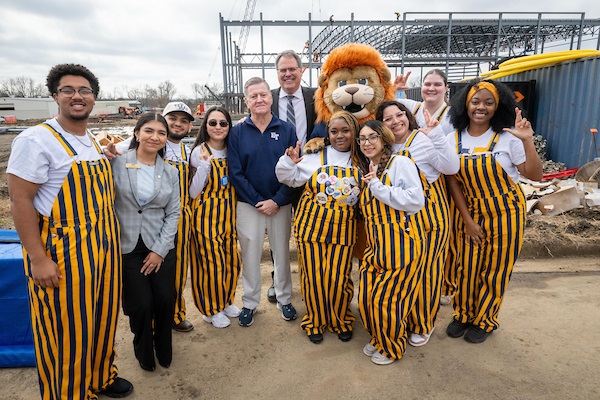 East Texas A&M Commerce February 2026 ETAMU students stand in front of the construction project with Rene’ Griffin, President Mark Rudin and Lucky the Lion (center) | Photo credit: Jason Connel, ETAMU Marketing and Communications
